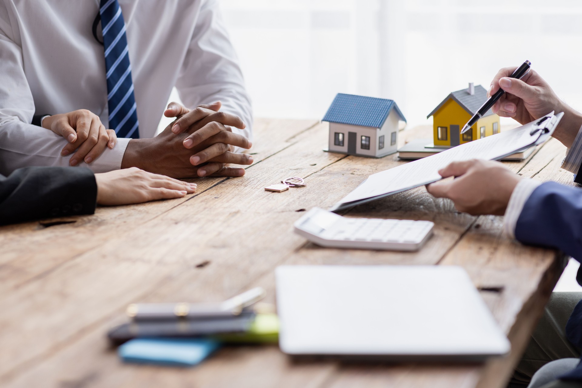 Real estate broker agent presenting and consult to customer to decision making sign insurance form agreement, buy and sell home model, concerning mortgage loan offer for and house insurance.